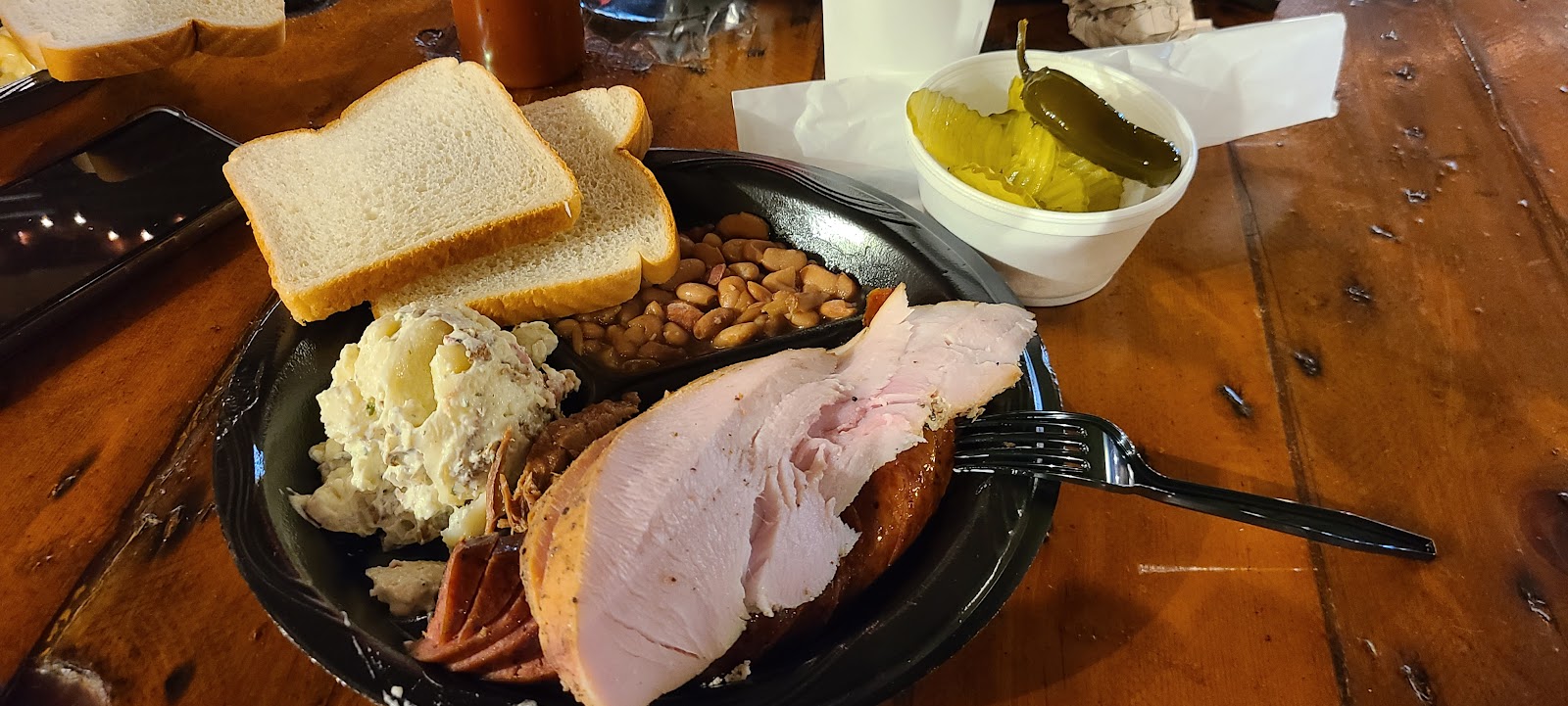Smoked turkey plate with potato salad, pinto beans, pickles and white bread